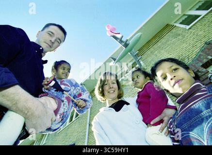 Familie Keesma, H'lem, Haarlem, Niederlande, 22-02-2001 Whizgle News, Dutch Desk, Niederlande, 1950-2000 Eine Gruppe von vier Personen, darunter zwei Erwachsene und zwei Kinder, lächelt zusammen vor einem Gebäude. Die Kinder tragen bunte Kleidung, während die Erwachsenen freundlich und engagiert wirken. Im Hintergrund ist eine verspielte Dekoration auf der Struktur zu sehen. Stockfoto
