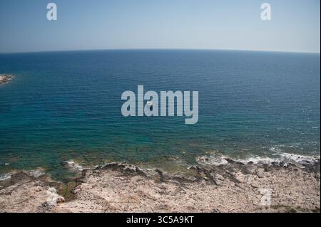 Malerischer Blick auf den Steinstrand und das Segelboot in Kroatien Stockfoto