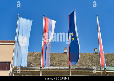 Novi-Sad, Serbien - 06.05.2021: Fliegende Fahnen auf blauem Himmel. Die Flagge Serbiens und die Flagge der Europäischen Union Stockfoto