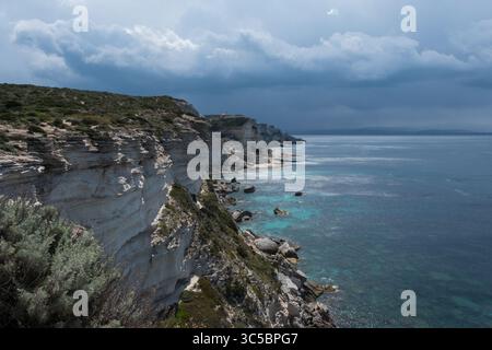 Eindrucksvolle Küstenklippen in Korsika, Frankreich, die sich über dem Mittelmeer erheben, mit dramatischem Licht und Texturen. Eine raue Naturlandschaft Stockfoto