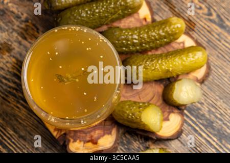 Eingelegte Gurken und eingelegte reife Gurken neben einem Glas, eingelegte Gurken mit Gewürzen und ganze knusprige Gurken auf ein Brett, Nahaufnahme Stockfoto