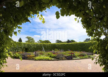 Blick auf den Blumenkreis Lindenrund mit bronzener Speerwerferstatue von 1937 von Ernst Seger im Hintergrund vor Hecke, Grugapark, Essen Stockfoto