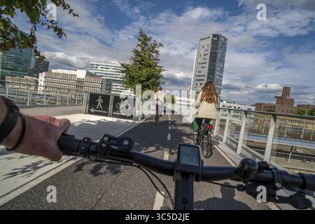 Radfahren über die Moreelse brug, Fußgänger- und Radfahrerbrücke über die Gleise von Utrecht Centraal, Hauptbahnhof, Rabobank Stockfoto