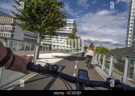 Radfahren über die Moreelse brug, Fußgänger- und Radfahrerbrücke über die Gleise von Utrecht Centraal, Hauptbahnhof, Rabobank Stockfoto