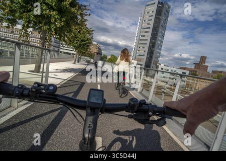 Radfahren über die Moreelse brug, Fußgänger- und Radfahrerbrücke über die Gleise von Utrecht Centraal, Hauptbahnhof, Rabobank Stockfoto