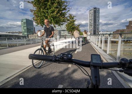 Radfahren über die Moreelse brug, Fußgänger- und Radfahrerbrücke über die Gleise von Utrecht Centraal, Hauptbahnhof, Rabobank Stockfoto