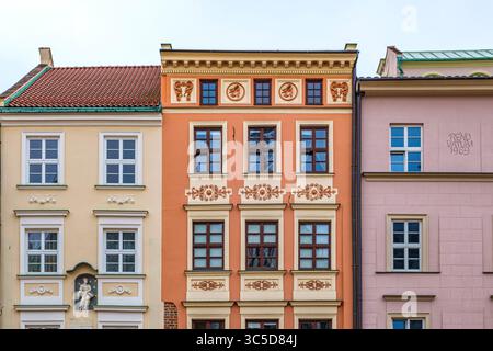 Direkter Blick auf die kunstvollen und farbenfrohen Fassaden traditioneller Stadthäuser im historischen Stadtzentrum von Kraków, Polen, das zum UNESCO-Weltkulturerbe gehört Stockfoto