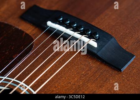 Nahaufnahme des Sattels einer braunen, hölzernen Mahagoni-Westergitarre Stockfoto