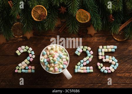 Festliches Silvester, Zahlen 2025 aus Marshmallows und heißer Schokolade, Weihnachtsdekoration auf hölzernem Hintergrund Stockfoto