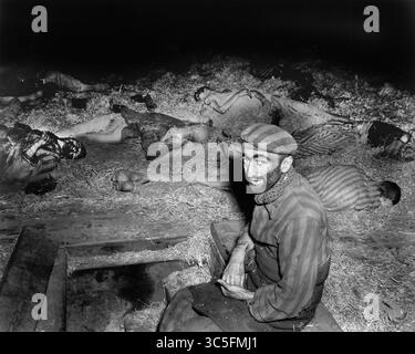16. Januar 2020, Deutschland: Ausgehungerter französischer Gefangener sitzt unter Toten im deutschen Sklavenarbeitslager zur Zeit der Befreiung durch die US-Armee, Nordhausen, Deutschland, Foto von Roberts für das US-Army Signal Corps, April 1945 (Credit Image: © JT Vintage/Glasshouse Via ZUMA Wire) Stockfoto