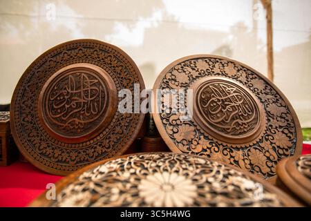 Blumenschnitzerei mit arabischer Kalligraphie auf dem Souvenirteller. Stockfoto