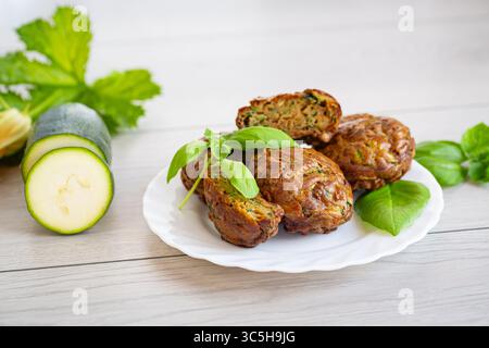 Zucchini-Muffins in minimalistischer Komposition auf einem hellen Holztisch. Stockfoto