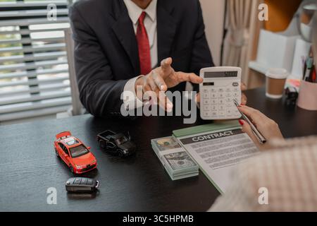 Ein Autoverkäufer erklärt die Details eines Autos und den Preis, an dem ein Käufer interessiert ist, der Verkaufsleiter des Verkaufsraums erläutert die Menge an Int. Stockfoto