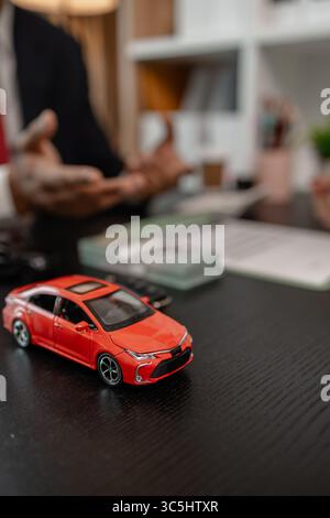 Ein Autoverkäufer erklärt die Details eines Autos und den Preis, an dem ein Käufer interessiert ist, der Verkaufsleiter des Verkaufsraums erläutert die Menge an Int. Stockfoto