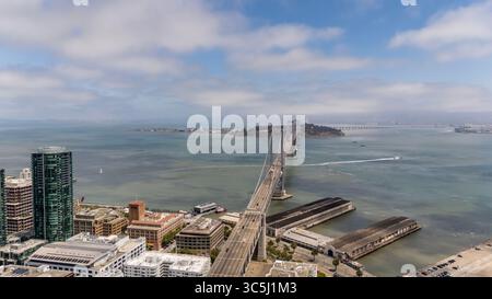 SAN FRANCISCO, CA USA - 28. Juli 2025: Die Bay Bridge, die sich über die Bucht von San Francisco erstreckt, verbindet San Francisco und Oakland mit ihren Doppeldecks und der auffälligen Aufhängung. Stockfoto
