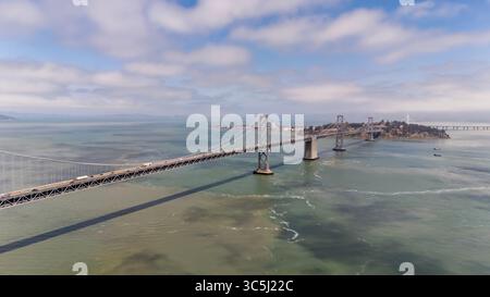 SAN FRANCISCO, CA USA - 28. Juli 2025: Die Bay Bridge, die sich über die Bucht von San Francisco erstreckt, verbindet San Francisco und Oakland mit ihren Doppeldecks und der auffälligen Aufhängung. Stockfoto