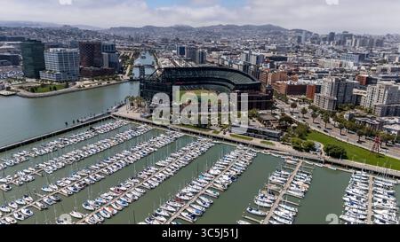 SAN FRANCISCO, CA USA - 28. Juli 2025: Ein Blick aus der Vogelperspektive von McCovey Cove zeigt Boote und Kajaks, die sich unter dem rechten Feld des Oracle Parks versammeln, wo Fans auf Bälle im malerischen Wasser der San Francisco Bay warten. Stockfoto