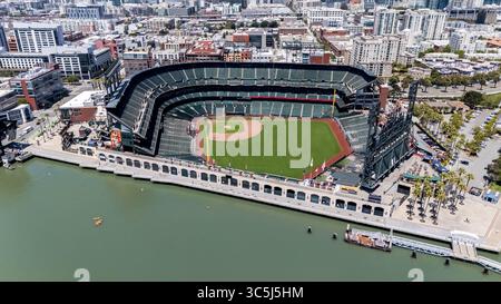 SAN FRANCISCO, CA USA - 28. Juli 2025: Ein Blick aus der Vogelperspektive von McCovey Cove zeigt Boote und Kajaks, die sich unter dem rechten Feld des Oracle Parks versammeln, wo Fans auf Bälle im malerischen Wasser der San Francisco Bay warten. Stockfoto