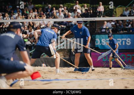 Düsseldorf, Deutschland. 30. Juli 2025. Beachvolleyball: Europameisterschaften, Männer, Gruppenbühne, Rochusclub. Rotar/Gauthier-Rat (Frankreich) - Just/Huster (Deutschland). Freiwillige bereiten den Sand auf dem Mittelfeld vor. Quelle: Marius Becker/dpa/Alamy Live News Stockfoto