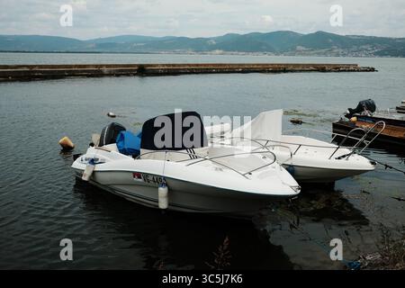 Zwei kleine weiße Boote legten an einem ruhigen Sommertag an der Donau an. Golubac, Serbien - 16. Juli 2025. Stockfoto