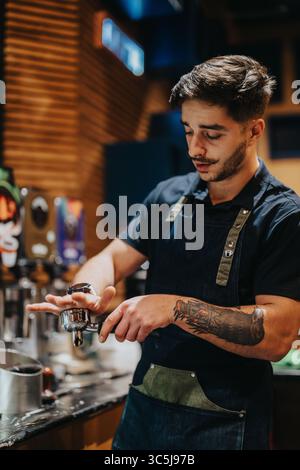 Der Barista bereitet Kaffee mit Sorgfalt in einem gemütlichen, modernen Café zu Stockfoto