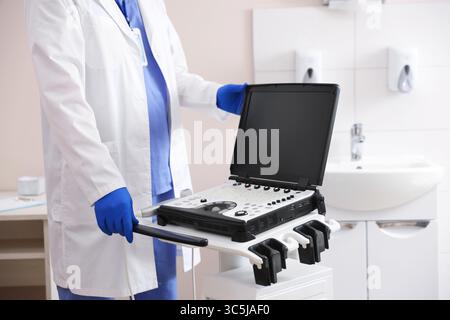 Professionelle Sonographin mit Ultraschallgerät in der Klinik, Nahaufnahme Stockfoto