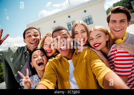 Vielfältige Gruppe junger Freunde, die gemeinsam einen sonnigen Tag im Freien in der Stadt genießen und Freude und Freundschaft zeigen Stockfoto