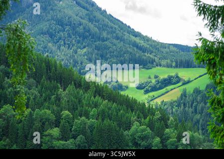 Blick auf das Tal von der Spitze der Alpenberge vor dem Hintergrund des Himmels in dicken Wolken Stockfoto