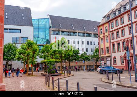 Frankfurt, Deutschland - 10. Juni 2025: Markanter Kontrast zwischen moderner Architektur und traditionellen Gebäuden in einer lebendigen Frankfurter Straßenszene, Stockfoto