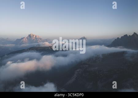 Aus der Vogelperspektive auf die Gipfel des Monte Cristallo, die durch ein Meer aus ätherischen Wolken durchdringen, eine Symphonie aus Licht und Schatten, die über die Dolomiten tanzt., Misurina, Dolomiten, Italien. Stockfoto