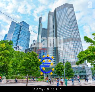 Frankfurt, Deutschland - 10. Juni 2025: Moderne Wolkenkratzer umgeben den ikonischen Eurotower in Frankfurt, Deutschland und schaffen eine lebendige urbane Atmosphäre mit l Stockfoto