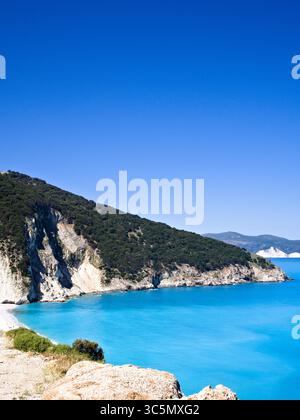 Panoramablick auf Myrtos Beach auf der Insel Kefalonia mit türkisfarbenem Wasser, weißen Klippen und üppigem Küstengrün. Stockfoto