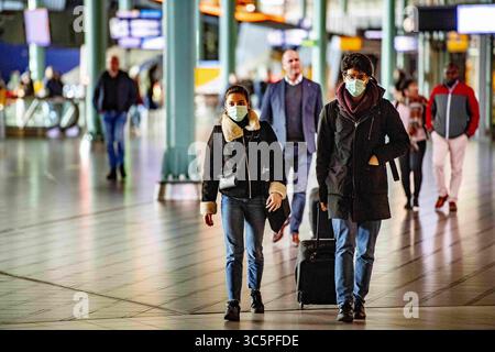 17. März 2020, Schiphol, Niederlande: Reisende mit Gesichtsmasken als Schutzmaßnahme vor dem Eindringen des COVID-19-Coronavirus gesehen. Mehrere Fluggesellschaften stornierten Flüge, da die Nachfrage nach internationalen Reisen aufgrund des Ausbruchs des COVID-19-Coronavirus sinkt. Mehrere europäische Länder haben Grenzen geschlossen, Schulen und öffentliche Einrichtungen geschlossen und die meisten großen Sport- und Unterhaltungsveranstaltungen abgesagt, um die Verbreitung des tödlichen Virus zu verhindern. (Credit Image: © Robin Utrecht/SOPA Images via ZUMA Wire) Stockfoto