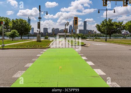 Cambridge, MA, USA-15. Juli 2025: Komplette Straßengestaltung mit Radweg, Fußgängerüberquerung und Verkehrszeichen mit den Wolkenkratzern von Boston in der Stockfoto