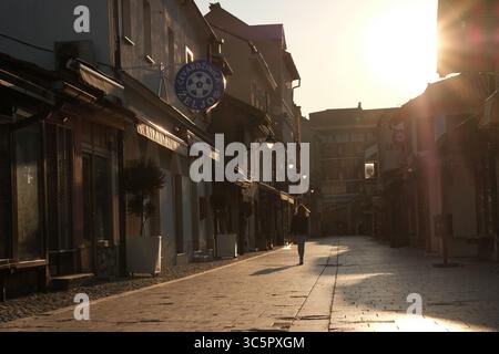 20. März 2020 - Sarajevo, Bosnien und Herzegowina - Eine Frau läuft an geschlossenen Unternehmen in einer leeren Straße im Stadtzentrum von Sarajevo vorbei. Nicht unbedingt notwendige Unternehmen bleiben geschlossen, um eine weitere Ausbreitung des Coronavirus zu verhindern. (Bild: © Nick St.Oegger/ZUMA Wire/ZUMAPRESS.com) Stockfoto