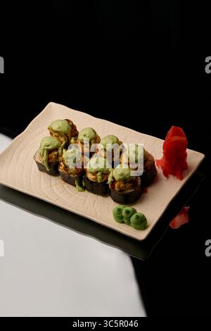 japanische Küche. Sushi auf einem Teller auf schwarzem Hintergrund Stockfoto