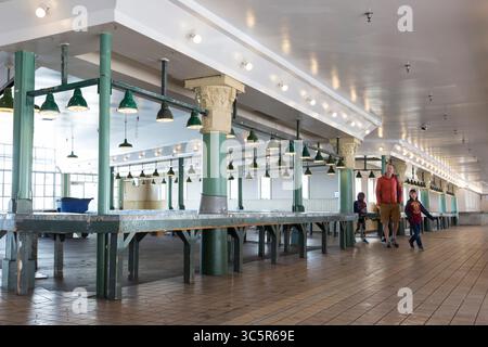 März 2020, Seattle, Washington, USA: Besucher spazieren am Sonntag, 22. März 2020 durch eine leere Arkade am Pike Place Market. Während viele der Lebensmittelgeschäfte geöffnet sind, sind die nicht unbedingt notwendigen Geschäfte der landmarkâ vorübergehend geschlossen, einschließlich der allgegenwärtigen Souvenir- und Blumenstände der marketâ. (Foto: © Paul Christian Gordon/ZUMA Wire) Stockfoto