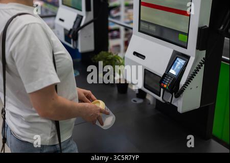 Eine Frau scannt Artikel an einer Selbstkasse. Stockfoto