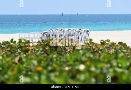26. März 2020, Miami Beach, Florida, USA: Gestapelte Liegestühle am leeren Strand von South Beach aufgrund von Notfallmaßnahmen, die von der Stadt Miami Beach im Zusammenhang mit der COVID-19-Pandemie ergriffen wurden, um alle Parks, Strände, Freizeiteinrichtungen, Restaurants, Cafés und Hotels zu schließen. (Bild: © Taimy Alvarez/ZUMA Wire) Stockfoto