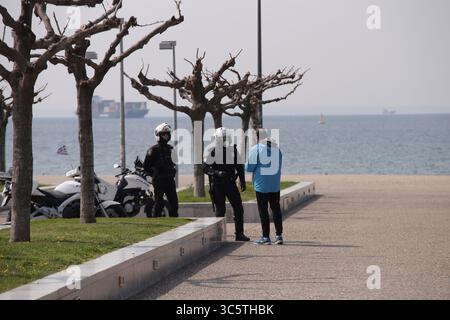 31. März 2020, Thessaloniki, Griechenland: Die Polizei kontrolliert einen Mann auf seine notwendigen Papiere an der Seepromenade von Thessaloniki, nachdem sie beschlossen hatte, den Verkehr an der Seepromenade zu beschränken. Nikos Chardalias, der stellvertretende Minister für Katastrophenschutz und Krisenmanagement, hat heute Verkehrsbeschränkungen für bestimmte Tageszeiten an der Strandpromenade angeordnet, eine weitere vorbeugende Maßnahme gegen die Ausbreitung von COVID-19 in Griechenland. Diese Maßnahme wurde aufgrund des hohen Verkehrsaufkommens an der Seepromenade von Thessaloniki in den vergangenen Tagen trotz der landesweiten Sperrung beschlossen. (C Stockfoto