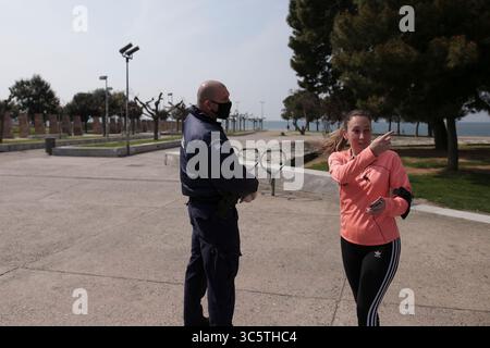31. März 2020, Thessaloniki, Griechenland: Die Polizei überprüft eine Frau auf ihre notwendigen Papiere an der Seepromenade von Thessaloniki, nachdem sie beschlossen hatte, den Verkehr an der Seepromenade zu beschränken. Nikos Chardalias, der stellvertretende Minister für Katastrophenschutz und Krisenmanagement, hat heute Verkehrsbeschränkungen für bestimmte Tageszeiten an der Strandpromenade angeordnet, eine weitere vorbeugende Maßnahme gegen die Ausbreitung von COVID-19 in Griechenland. Diese Maßnahme wurde aufgrund des hohen Verkehrsaufkommens an der Seepromenade von Thessaloniki in den vergangenen Tagen trotz der landesweiten Sperrung beschlossen. Stockfoto