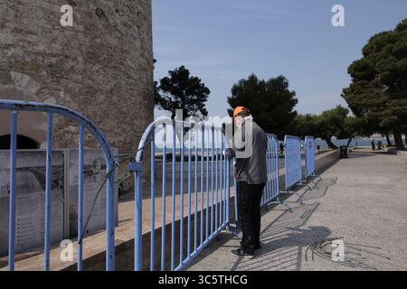 31. März 2020, Thessaloniki, Griechenland: Ein Arbeiter errichtet einen Schutzzaun vor dem Weißen Turm in Thessaloniki, nachdem er beschlossen hatte, den Verkehr an der Uferpromenade zu beschränken. Nikos Chardalias, der stellvertretende Minister für Katastrophenschutz und Krisenmanagement, hat heute Verkehrsbeschränkungen für bestimmte Tageszeiten an der Strandpromenade angeordnet, eine weitere vorbeugende Maßnahme gegen die Ausbreitung von COVID-19 in Griechenland. Diese Maßnahme wurde aufgrund des hohen Verkehrsaufkommens an der Seepromenade von Thessaloniki in den vergangenen Tagen trotz der landesweiten Sperrung beschlossen. (Kreditbild Stockfoto