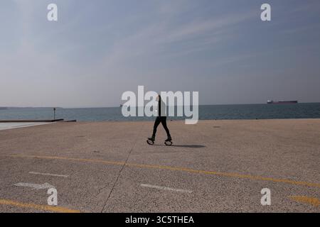 31. März 2020, Thessaloniki, Griechenland: Eine Frau läuft vor der Uferpromenade, nachdem beschlossen wurde, den Verkehr auf der Uferpromenade zu beschränken. Nikos Chardalias, der stellvertretende Minister für Katastrophenschutz und Krisenmanagement, hat heute Verkehrsbeschränkungen für bestimmte Tageszeiten an der Strandpromenade angeordnet, eine weitere vorbeugende Maßnahme gegen die Ausbreitung von COVID-19 in Griechenland. Diese Maßnahme wurde aufgrund des hohen Verkehrsaufkommens an der Seepromenade von Thessaloniki in den vergangenen Tagen trotz der landesweiten Sperrung beschlossen. (Kreditbild: © Achill Stockfoto