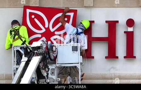 6. April 2020, Winter Park, FL, USA: Arbeiter, die Schilder für ein neues Hilton Garden Inn in Winter Park, Florida installieren, scheinen während der Arbeit am Montag, 6. April 2020 einen humorvollen Gruß zu erhalten. Das Hotel wird im Einkaufsviertel Ravaudage an der Lee Road an der North Orlando Avenue eröffnet. (Kreditbild: © TNS via ZUMA Wire) Stockfoto