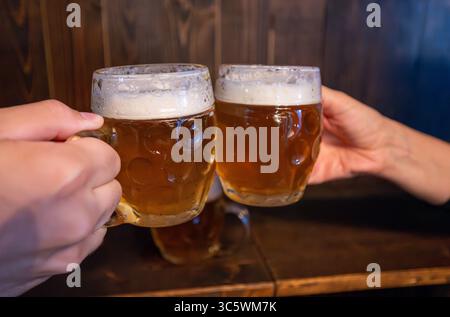 Prag, Tschechische Republik, August 5,2023. Zwei Bierbecher in einer Bierhalle in der Altstadt werden in einem Toast aufgezogen. Es ist das Nationalgetränk, ein Symbol der Stadt Stockfoto
