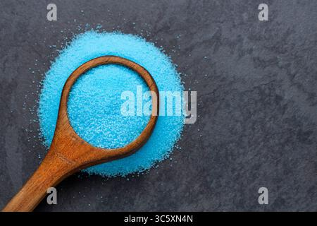 Feine blaue Salzkristalle im Löffel - Kaliumfluorid. Salz für den Glasrand Stockfoto