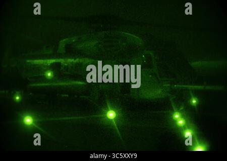 9. April 2020 - Philippinische See - Ein CH-53E Super Hengst Hubschrauber mit Marine Medium Tiltrotor Squadron (VMM) 265 (verstärkt), 31st Marine Expeditionary Unit (MEU), bereitet sich auf den Start vom Flugdeck des Amphibienangriffs USS America (LHA 6) während des Nachtfluges vor. Marines und Seeleute an Bord der USA führen regelmäßig Flugoperationen durch, um sicherzustellen, dass alle Geräte ordnungsgemäß funktionieren und Piloten die Möglichkeit geben, ihre Fähigkeiten zu verfeinern. America, Flaggschiff der America Expeditionary Strike Group, 31. MEU-Team, ist im Gebiet der 7. US-Flotte tätig Stockfoto