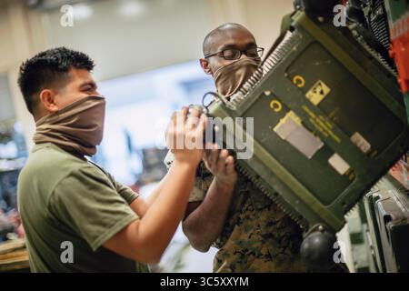 10. April 2020: Camp Pendleton, Kalifornien, USA: Mark Arcive (links) und Lance CPL. Isaiah Wilson, beide Field Radio Operators mit Bravo Company, 9th Communication Battalion, I Marine Expeditionary Force Information Group (MIG), bewegen eine Funkfrequenz-Einheit während einer Inventur im Marine Corps Base Camp Pendleton, Kalifornien, 10. April 2020. Die MIG bleibt auch unter COVID-19 einsatzbereit, indem sie die Ausrüstung aufrechterhält und die Arbeitsanstrengungen aufrechterhält und gleichzeitig soziale Distanzierungs- und Sanierungsverfahren durchführt. (Kreditbild: © Dalton Swanbeck/USA Marines/ZUMA Wire/Z Stockfoto