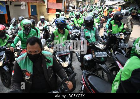5. September 2019, Cipayung, Jakarta, Indonesien: Online-Motorradfahrer stehen bereit, am 18. April 2020 Lebensmittel von Freiwilligen in der Gegend von Cipayung, Jakarta, zu kaufen. 200 Lebensmittelpakete wurden online an Motorradtaxifahrer verteilt, weil ihr Einkommen seit der Co-Pandemie in Indonesien zurückging. Von den vorherigen vielen Bestellungen für den Transport verwenden die Benutzer jetzt Fahrer, um Lebensmittel zu bestellen, für den täglichen Bedarf einzukaufen oder Waren zu liefern. (Bild: © Dasril Roszandi/ZUMA Wire) Stockfoto