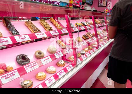Ein Mann schaut auf eine Vitrine voller Donuts Stockfoto